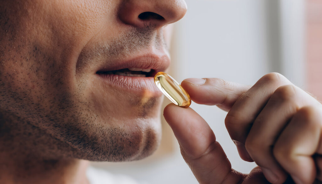 Man Taking Soft gel Supplement Close Up