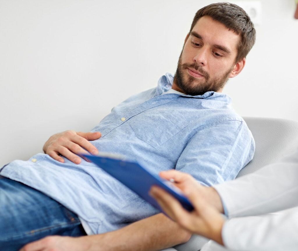 doctor with clipboard and young male patient having health problem meeting at a clinic