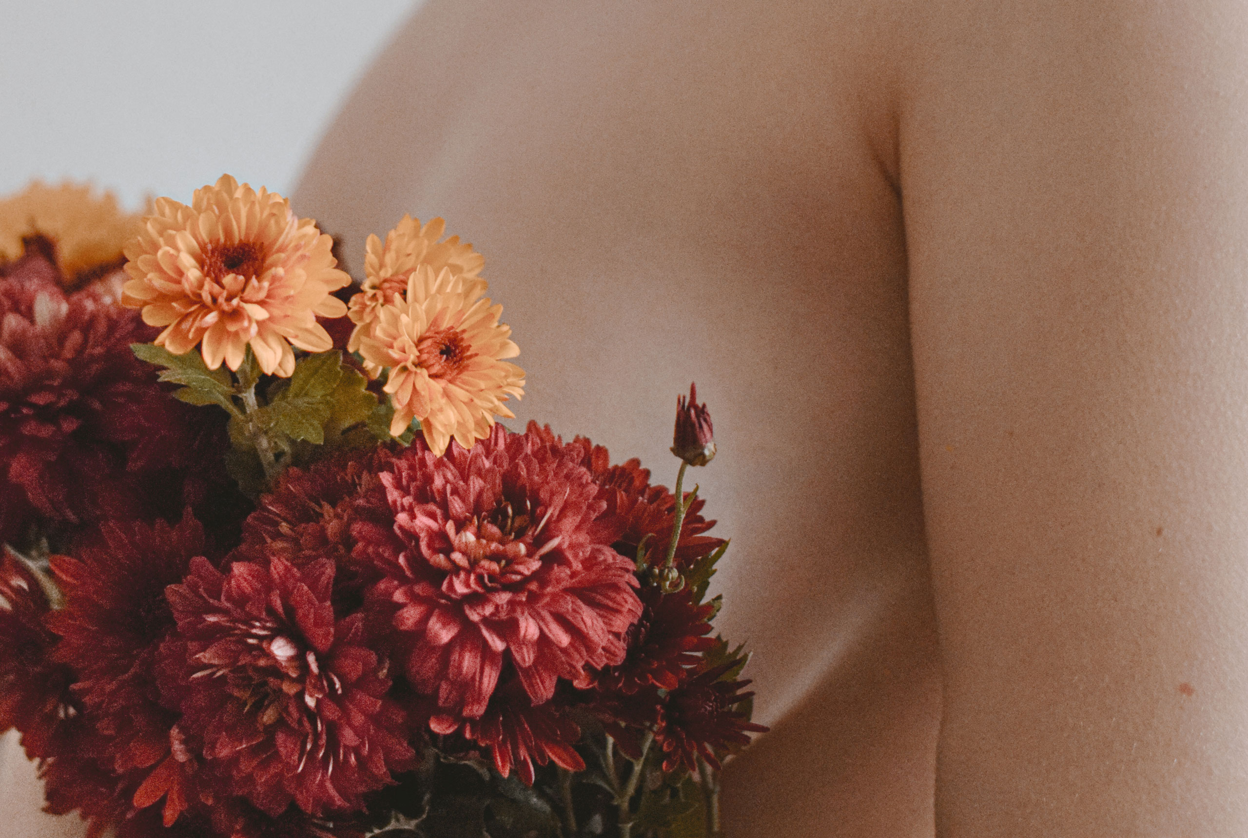 nude woman holding flowers in front of her silhouette