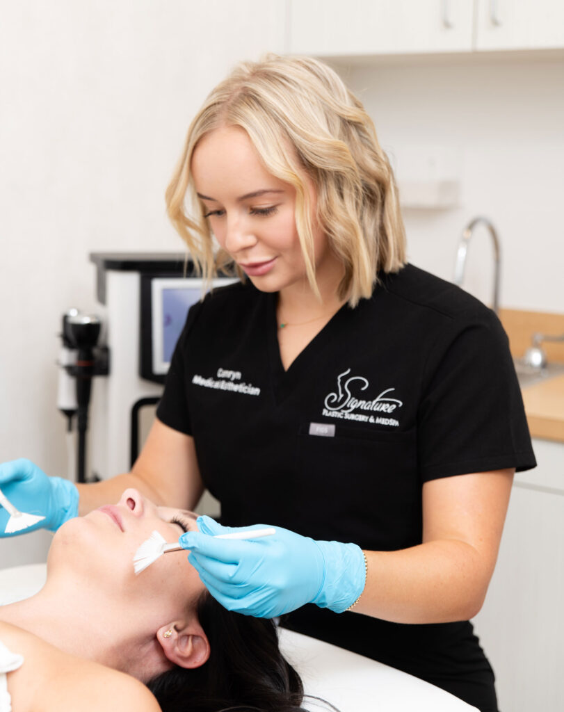 Esthetician preparing patient's face prior to a chemical peel in a clinic office